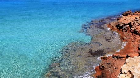 Tranquil Shoreline with Clear Waters and Rocky Edge wallpaper
