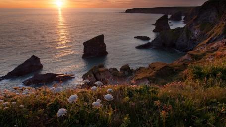 Serene Coastal Sunset Over Rocky Cliffs wallpaper