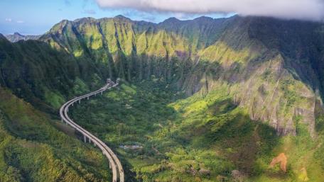 Majestic Mountain Roadway in Lush Green Landscape wallpaper