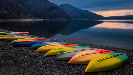 Vibrant Kayaks Resting by Serene Waters wallpaper