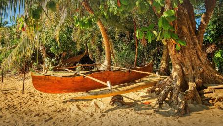 Tranquil Beach Scene with a Wooden Boat wallpaper