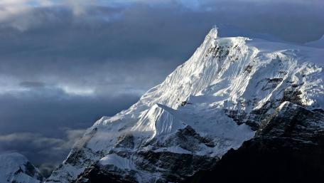 Majestic Snow-Capped Peaks Under Dramatic Skies wallpaper