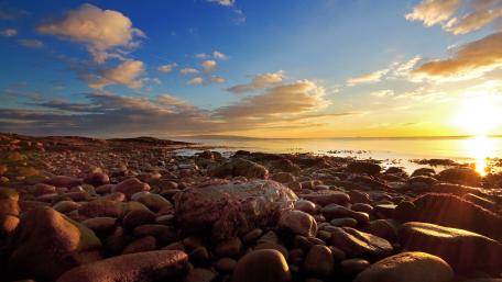 Tranquil Sunset Over Rocky Shoreline wallpaper