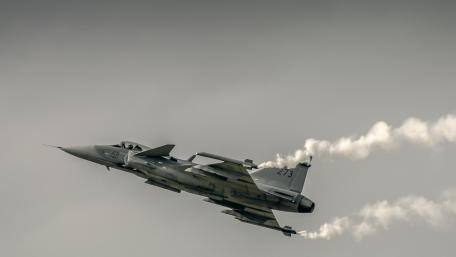 Dynamic Military Jet in Action Above Cloudy Skies wallpaper