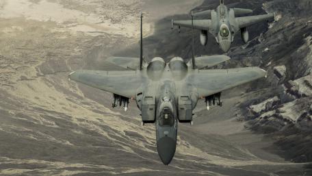 High-Flying Fighter Jets in Formation Above Rugged Terrain wallpaper