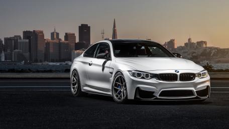 Sleek BMW M4 Against Urban Skyline at Sunset wallpaper