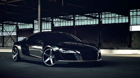Sleek Black Sports Car in Industrial Setting wallpaper