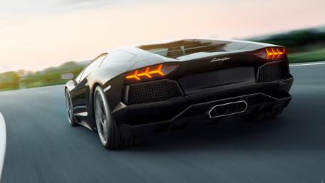 Sleek Black Supercar on the Open Road wallpaper