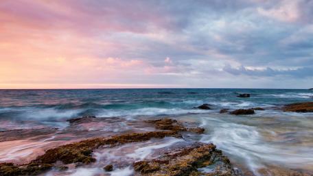 Serene Coastal Sunset Over Rocky Shoreline wallpaper