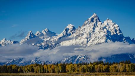 Majestic Snow-Capped Peaks Under Clear Blue Skies wallpaper