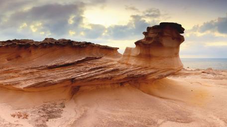 Serene Coastal Rock Formation Amidst Tranquil Skies wallpaper