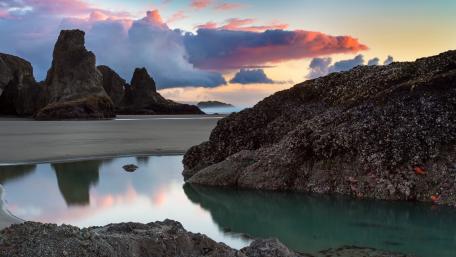 Serene Coastal Sunset Over Rocky Shoreline wallpaper