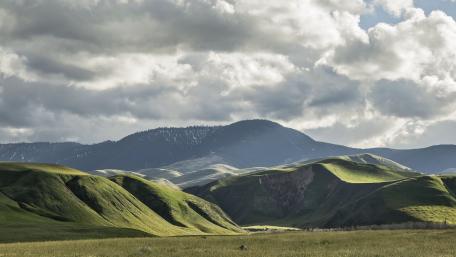Serene Rolling Hills Under Dramatic Skies wallpaper