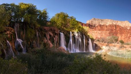 Majestic Waterfall Surrounded by Lush Nature wallpaper