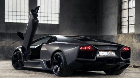 Sleek Black Lamborghini in an Industrial Setting wallpaper