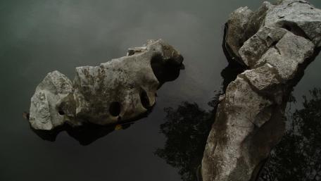 Mysterious Stones Reflecting Tranquility in Water wallpaper