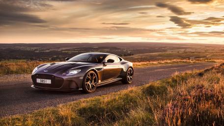 Sleek Aston Martin on a Scenic Sunset Road wallpaper