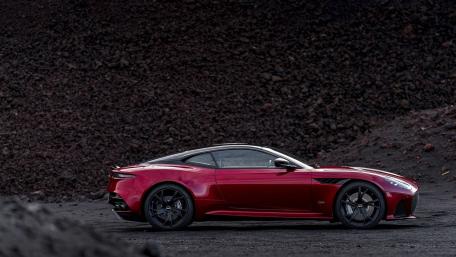 Sleek Red Sports Car Amidst Dark Landscape wallpaper