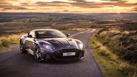 Sleek Aston Martin on a Scenic Road at Sunset wallpaper