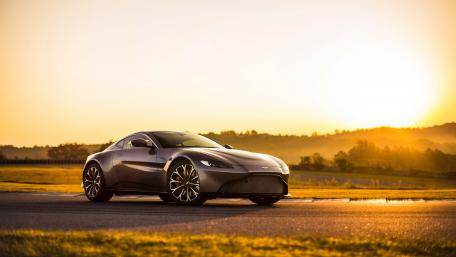 Sleek Luxury Car Against a Stunning Sunset Scene wallpaper