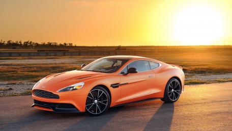 Sleek Orange Luxury Car Under Sunset Glow wallpaper