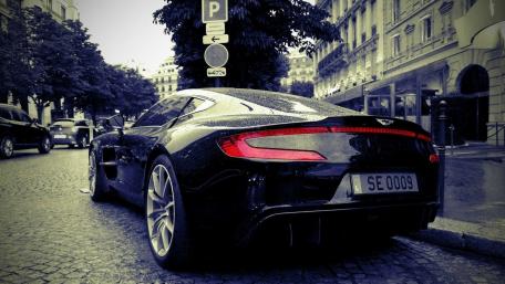 Sleek Black Sports Car Amidst City Vibes wallpaper