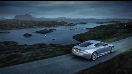 Sleek Silver Car on Serene Coastal Roadway wallpaper