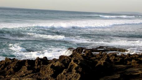 Serene Seashore Waves and Rocky Coastline wallpaper