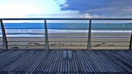 Serene Beach View with Calm Waters and Clouds wallpaper