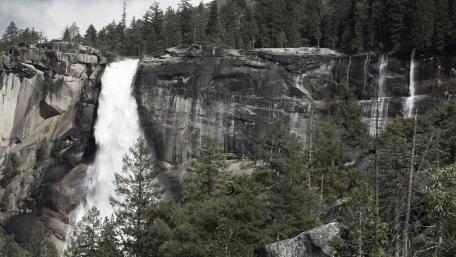 Majestic Waterfall Amidst Forest Serenity wallpaper