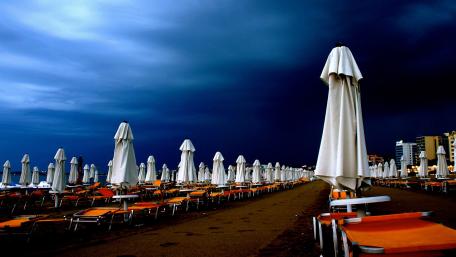 Dramatic Beach Scene Under Darkening Sky wallpaper