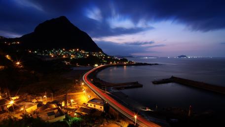 Nighttime Serenity Over Coastal Cityscape wallpaper