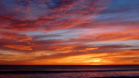 Vibrant Sunset Over Tranquil Ocean Waves wallpaper