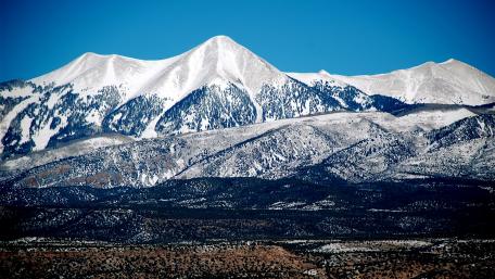 Majestic Snow-Capped Peaks Beneath a Clear Blue Sky wallpaper