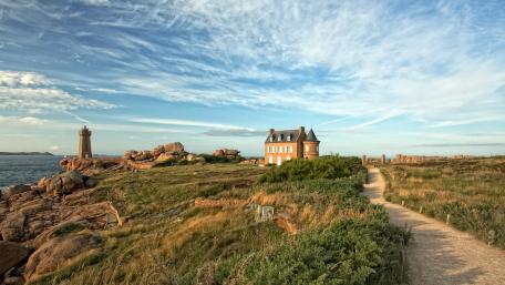 Seaside Serenity with Lighthouse and Cottage wallpaper