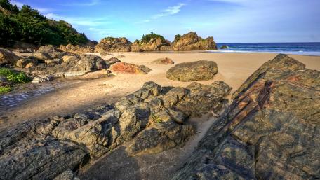 Serene Coastal Landscape with Rocky Shores and Tranquil Waters wallpaper