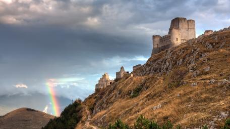 Majestic Castle Under a Vibrant Rainbow wallpaper