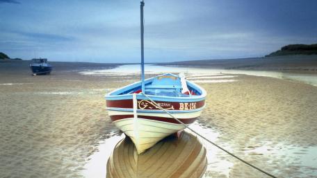 Tranquil Beach Scene with Boat on Sand Bar wallpaper