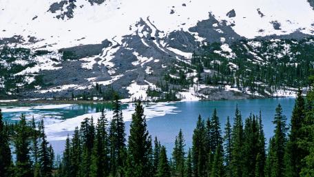 Serene Mountain Lake Amidst Lush Pine Forests wallpaper