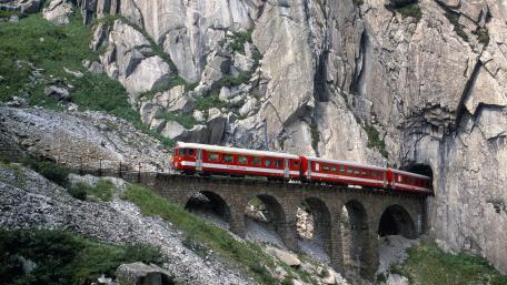Vibrant Train Journey Through Majestic Rocky Tunnel wallpaper