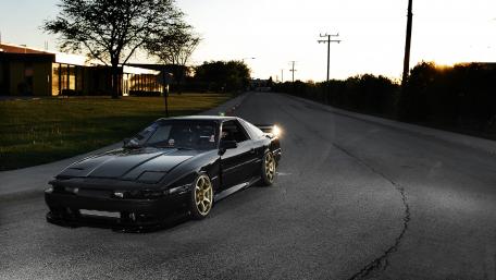 Sleek Black Sports Car at Sunset wallpaper