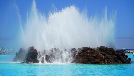Majestic Ocean Splashing Over Rocks wallpaper