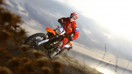 Dynamic Motorcycle Rider on a Scenic Terrain wallpaper