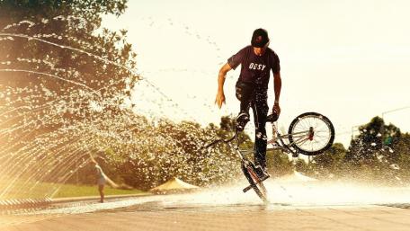 Dynamic BMX Rider in Action Amidst Water Spray wallpaper