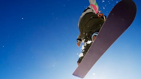 Snowboarder Soars Through Clear Blue Sky wallpaper