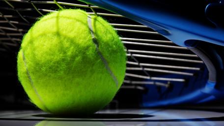 Dynamic Close-Up of a Tennis Ball and Racket wallpaper