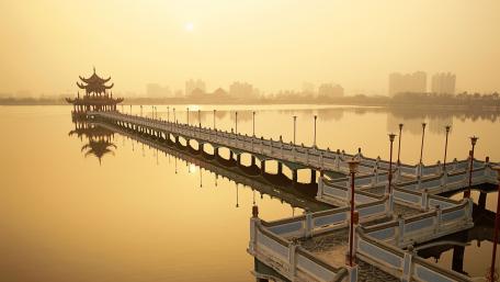 Serene Cityscape at Sunrise Over Water wallpaper