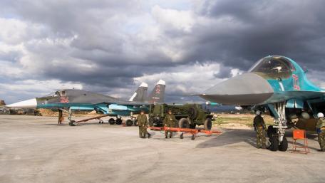 Military Aircraft on the Tarmac Under Cloudy Skies wallpaper