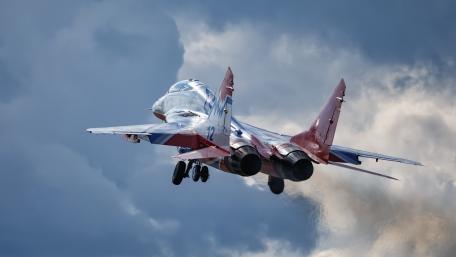 Dynamic Fighter Jet Soaring Through Cloudy Skies wallpaper
