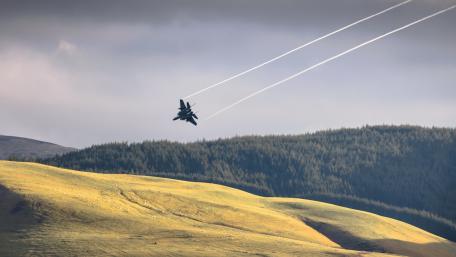 Majestic Fighter Jet Soaring Above the Mountains wallpaper